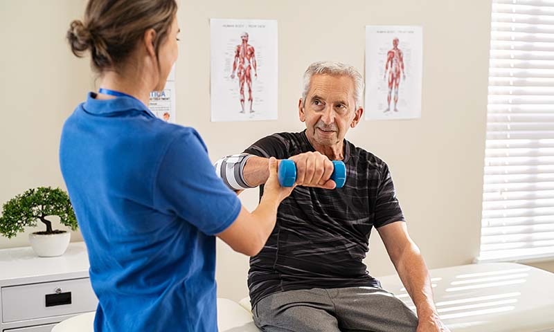 physical therapist helping a man with an exercise